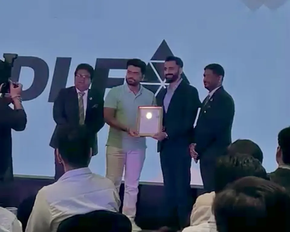 Bhola Estates receiving recognition on stage at a DLF event